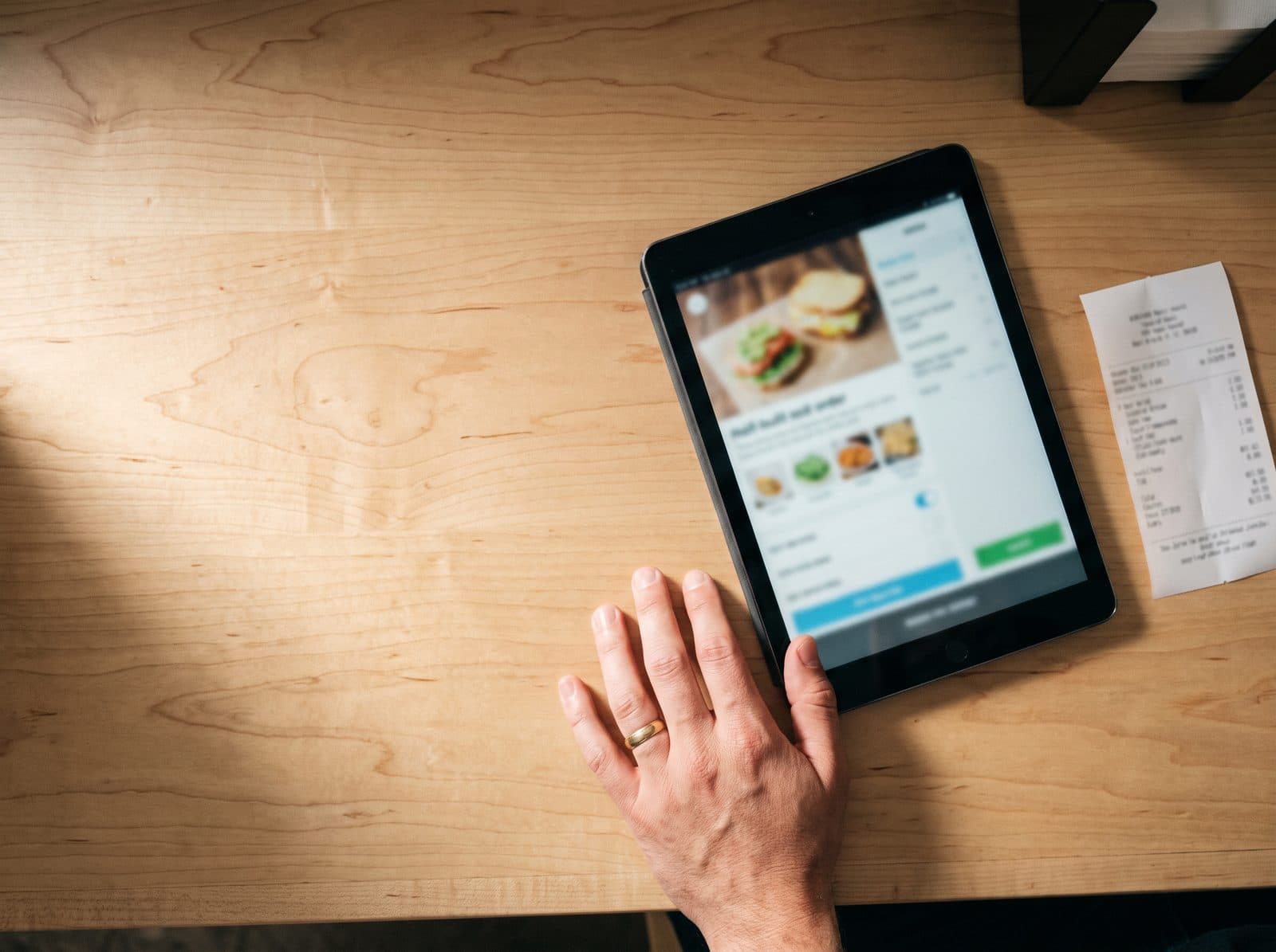 Un mostrador con una tablet y un ticket impreso